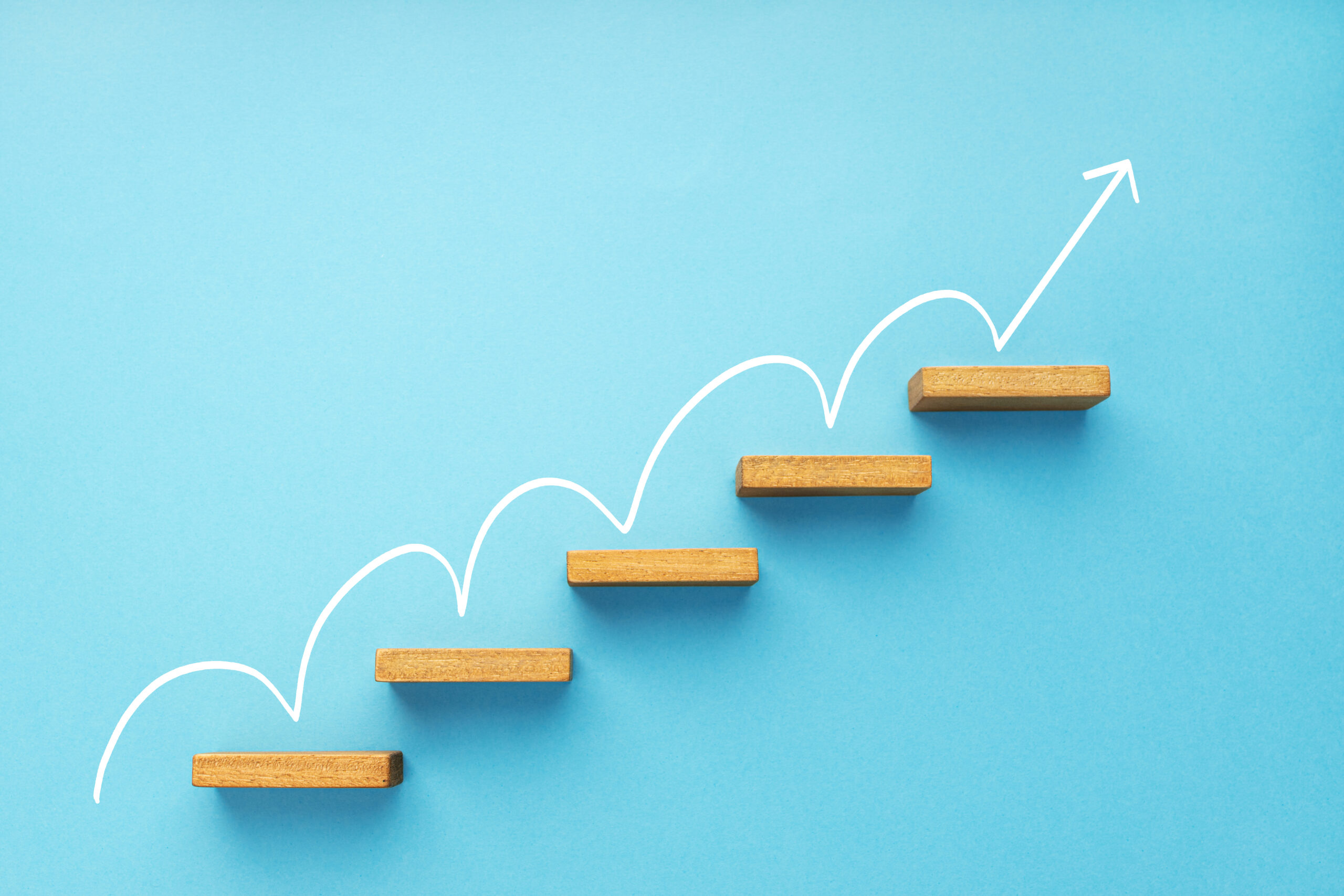 A rising arrow on a staircase with blue background symbolizing career growth.