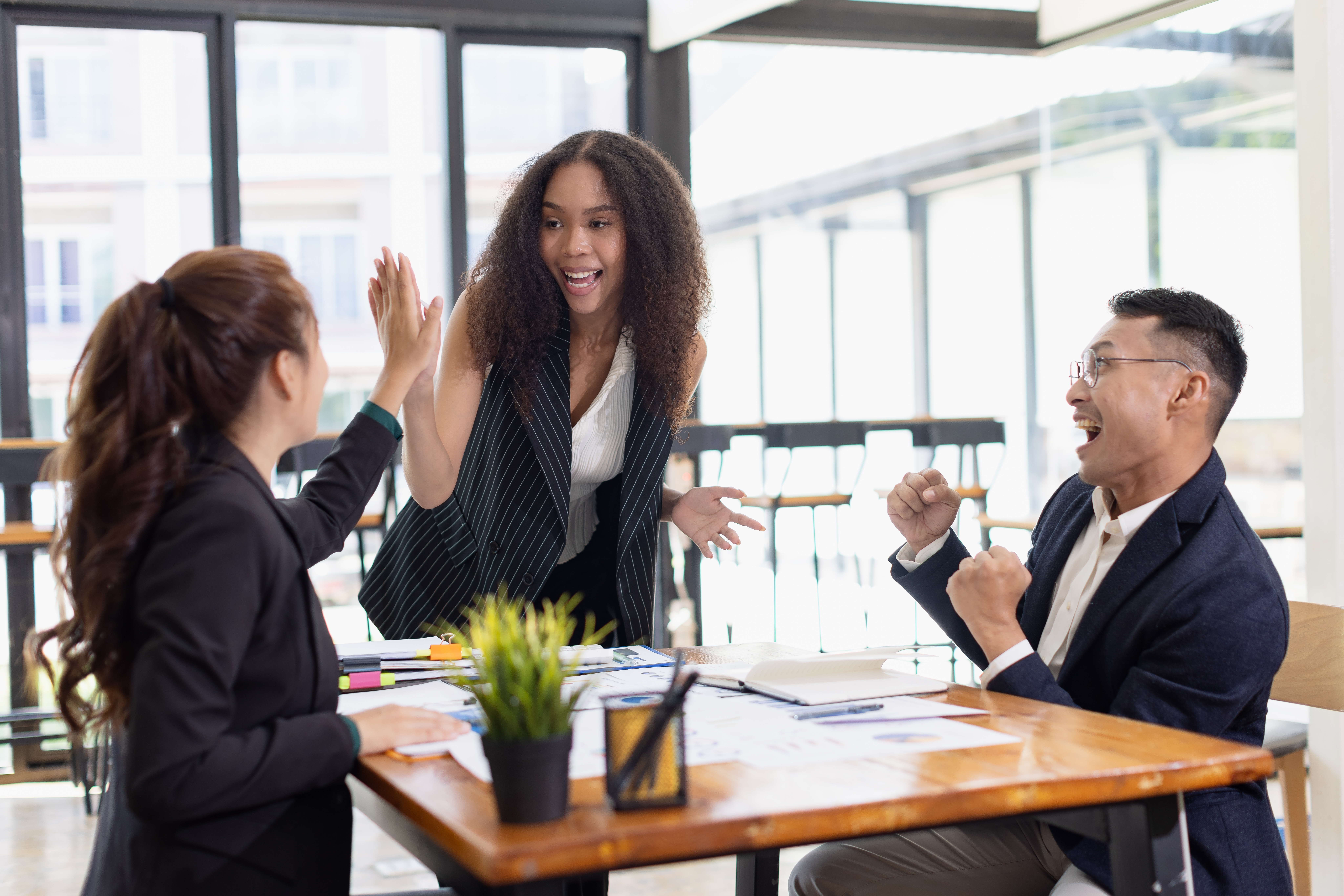 Happy and excited sales team celebrating success in the office.