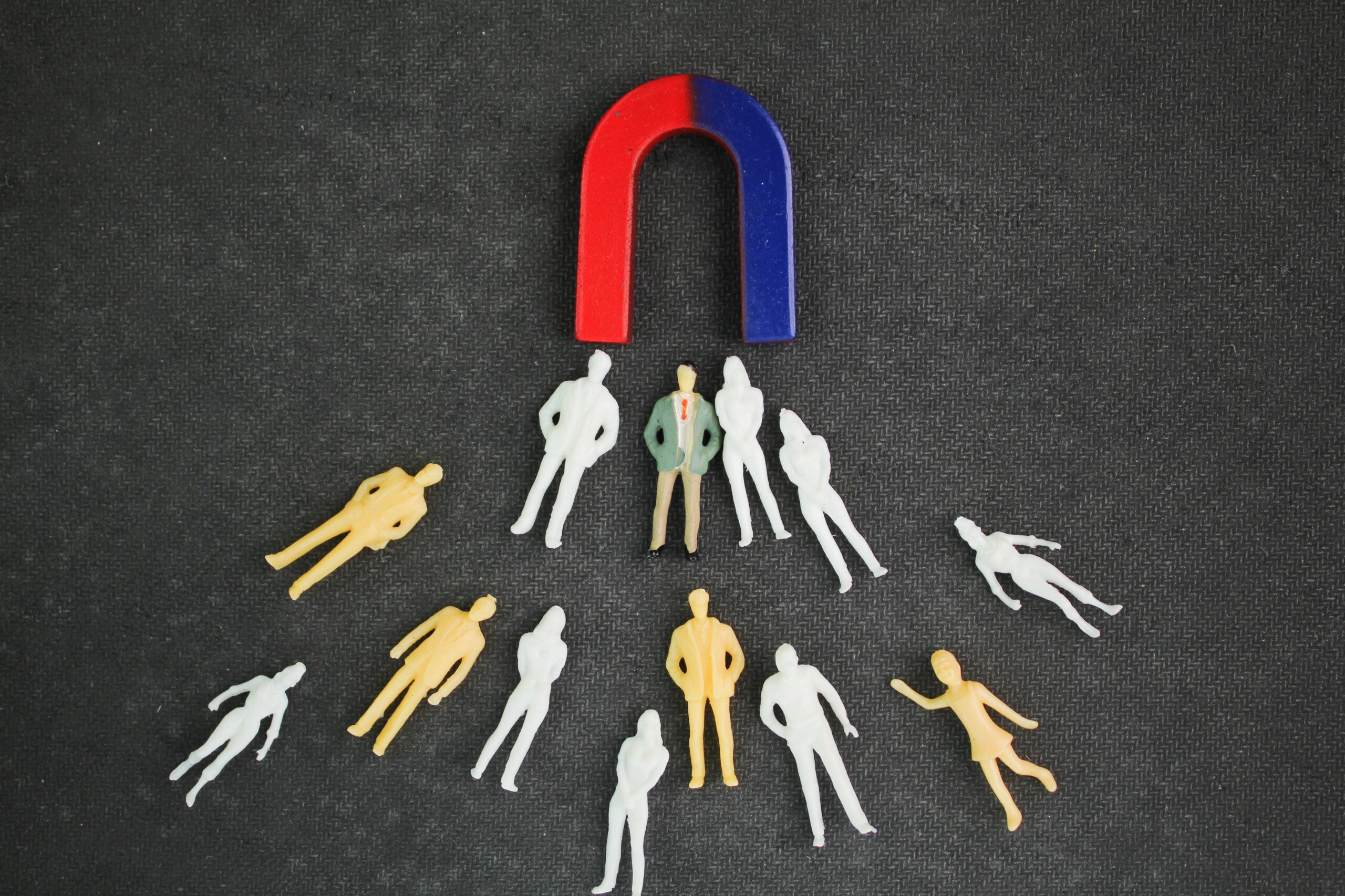 Small figures drawn toward a magnet illustrate a lead generation funnel and how prospects are attracted.